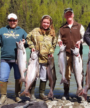 fishing group holding up their big king salmon