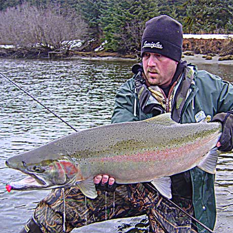 fisherman holding up large steelhead trout