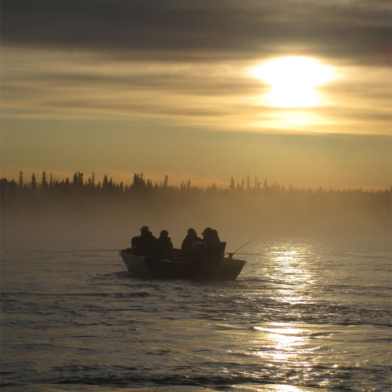people fishing from boat in fog on Kenai River