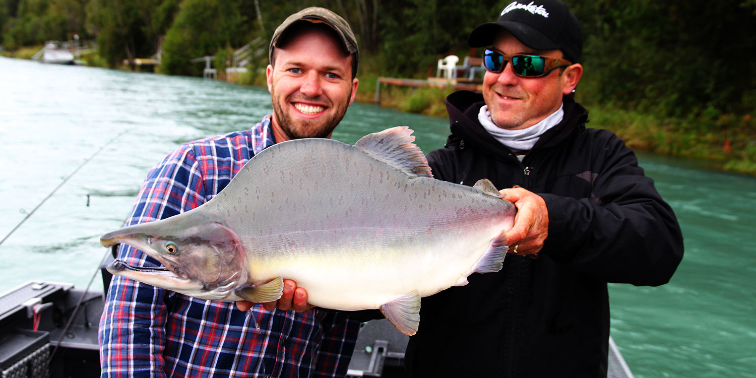 two gentlemen smiling big with their pink salmon