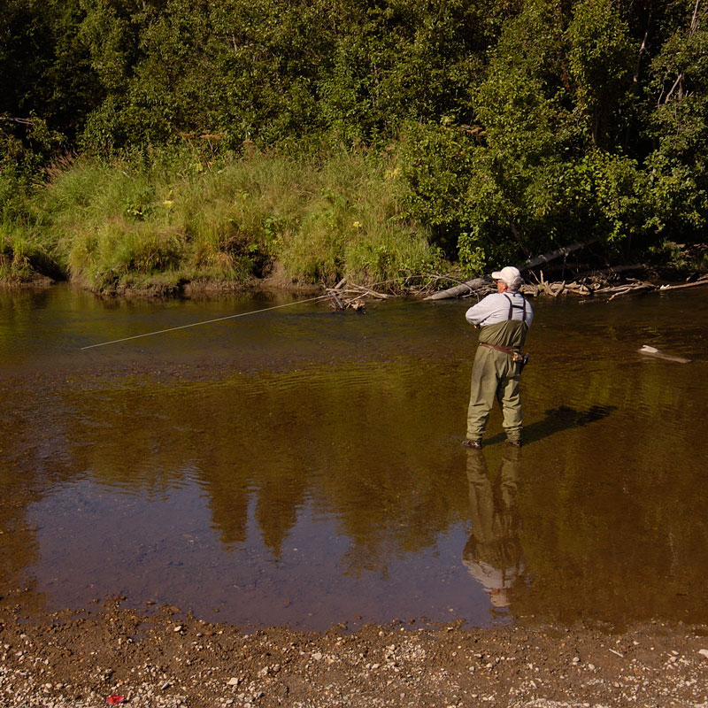 man fly fishing in river
