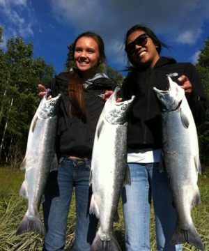 two young ladies holding up their Kenai silver salmon
