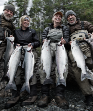 two couples holding two silver salmon each