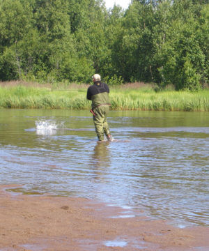 man fly fishing in remote area