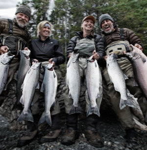 two happy couples holding two silver salmon each